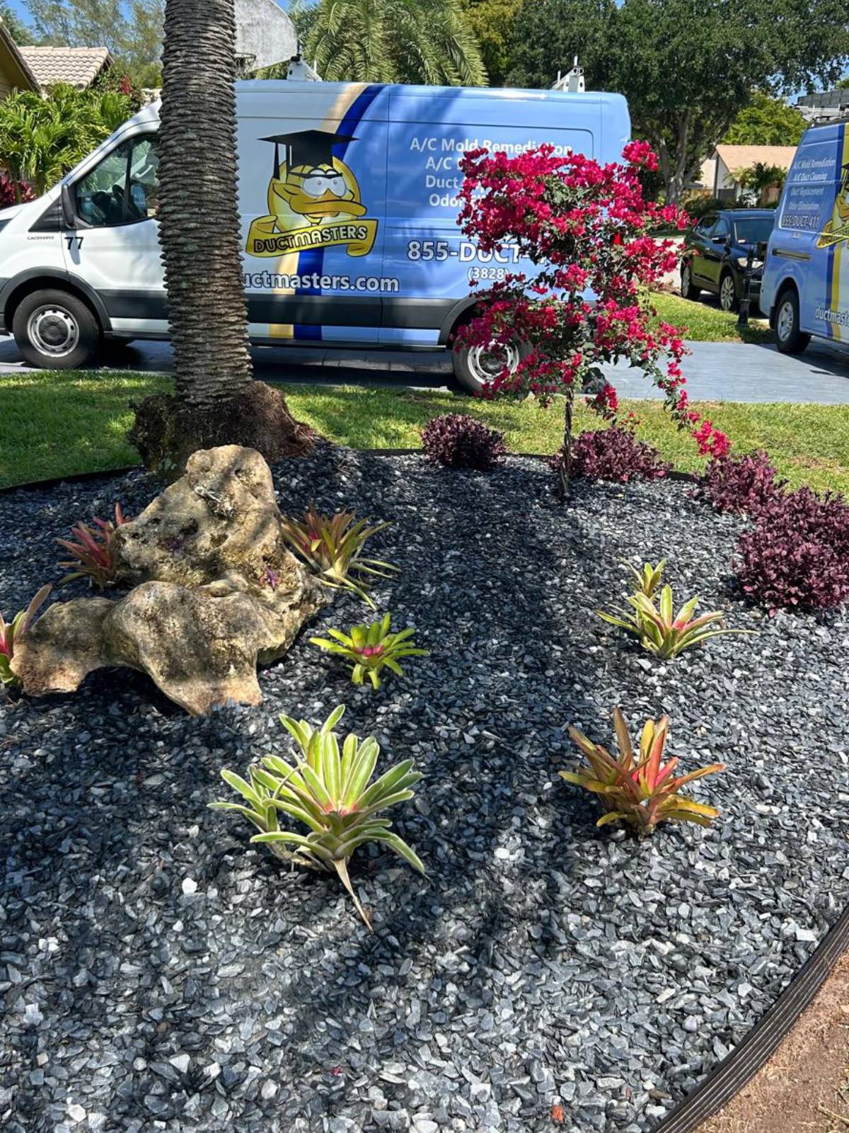 A truck parked in the driveway during a landscaping job, showcasing tools and materials for yard improvement.